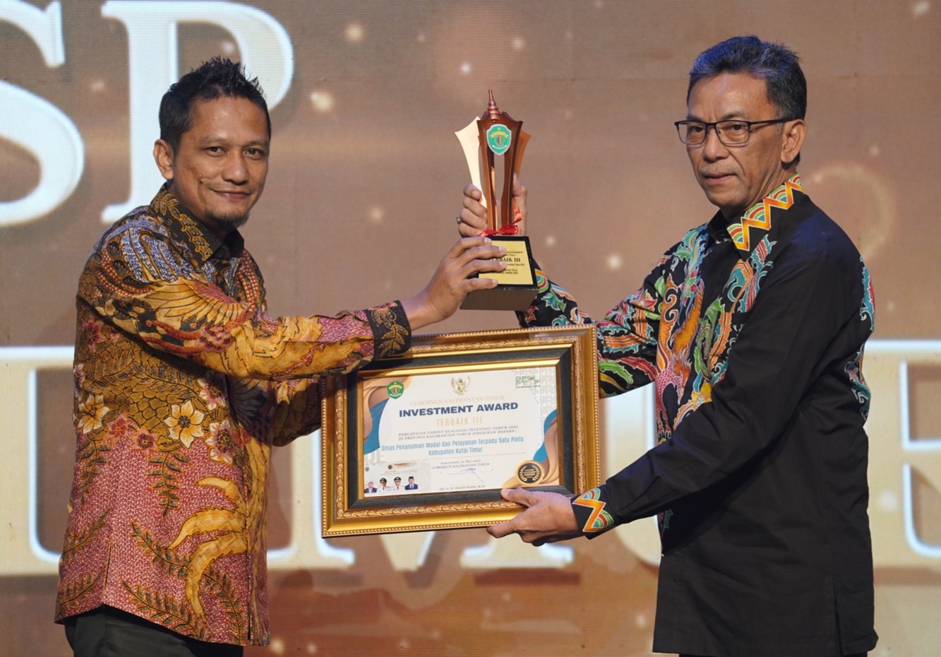 Kepala DPMPTSP Kutai Timur, Teguh Budi Santoso saat menerima piagam penghargaan Investment Award dari Kepala DPMPTSP Provinsi Kalimantan Timur, Puguh Harjanto (Pro Kutim)